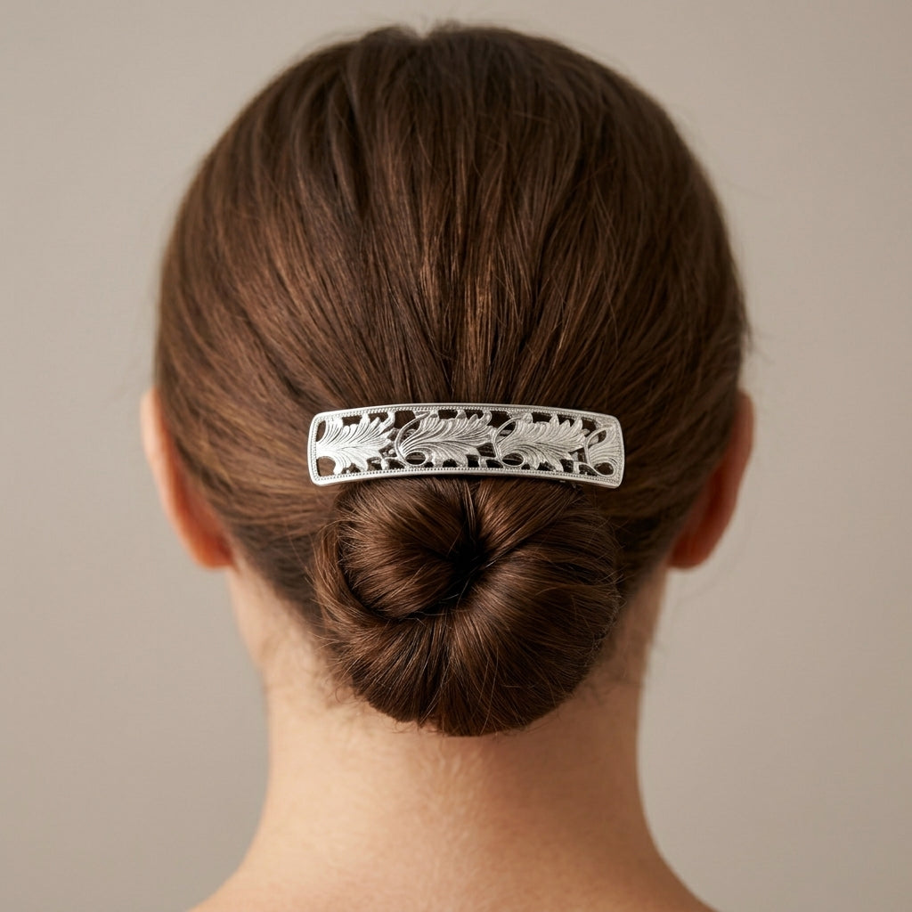 Person with a decorative hair clip in their bun against a neutral background