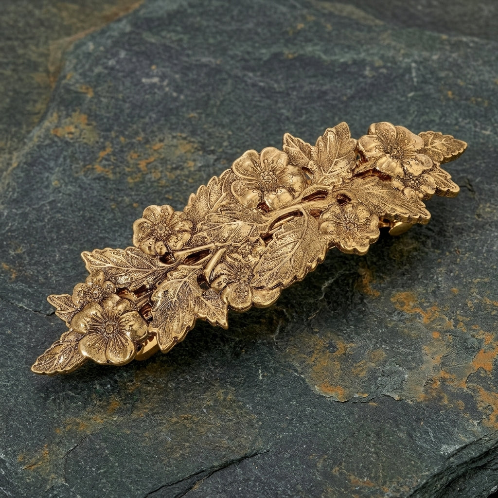 Gold floral barrette on a dark stone surface