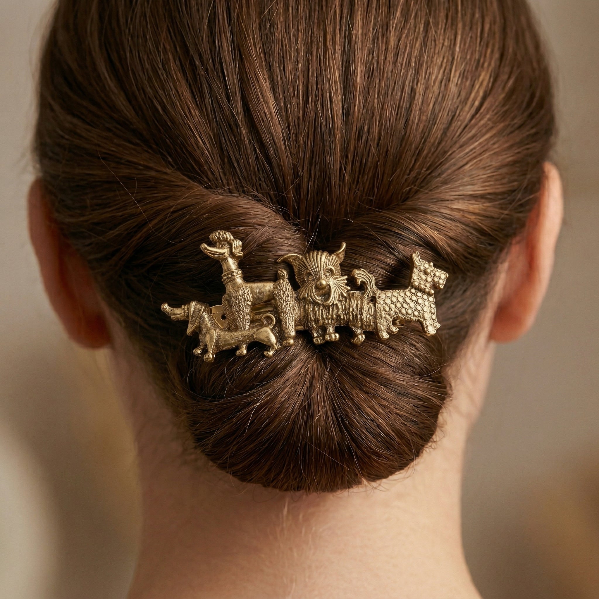 Hair bun with decorative hair barrette featuring multiple dog breeds on a neutral background