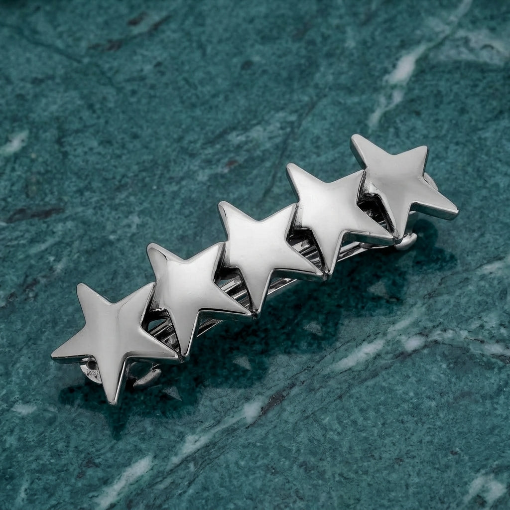 5 Star Polished Silver Hair Barrette on a textured green surface