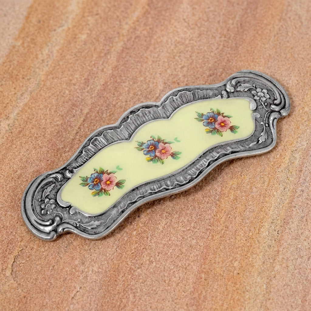 Blue And Pink Floral Hair Barrette on a textured light stone surface