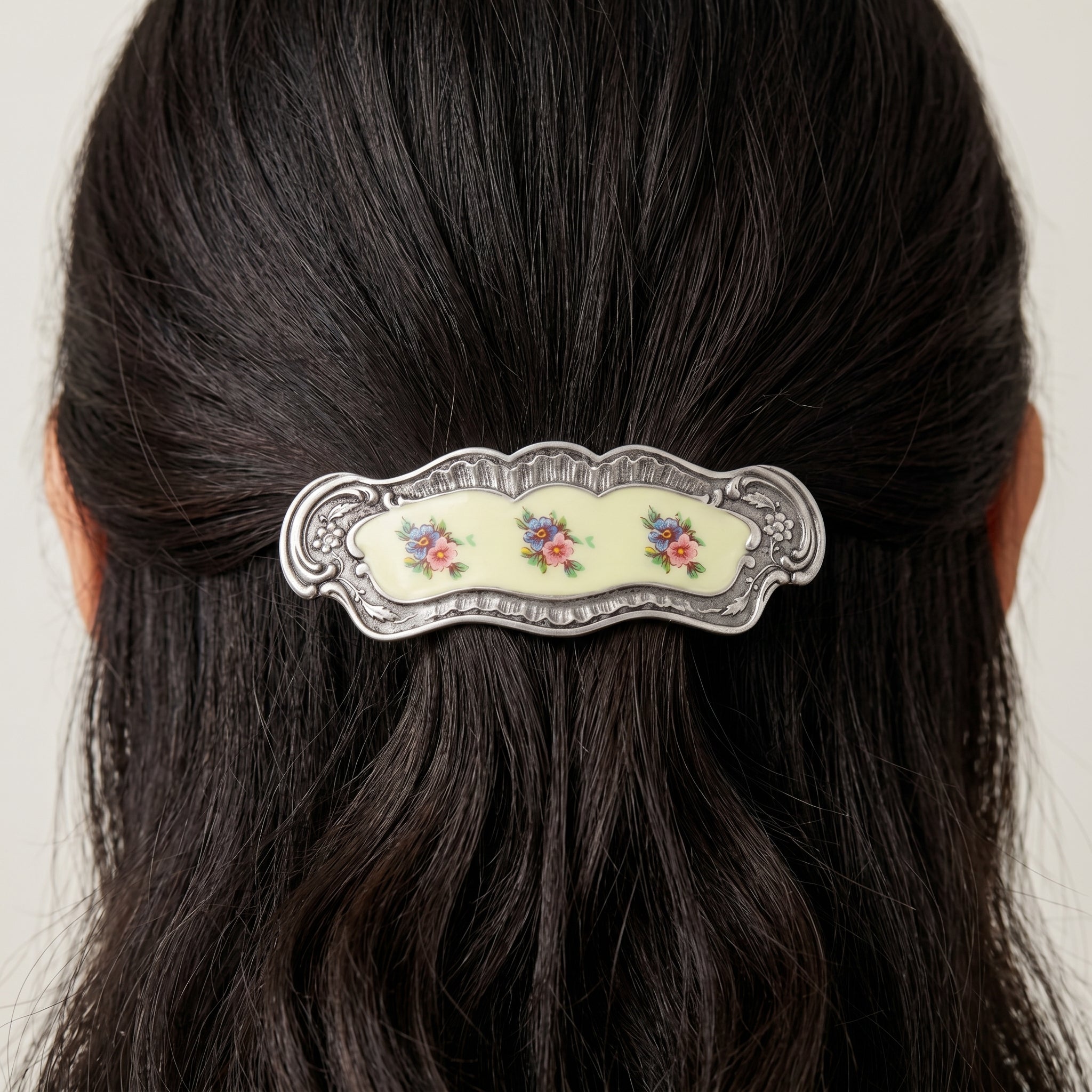 Blue And Pink Floral Hair Barrette on dark hair against a white background