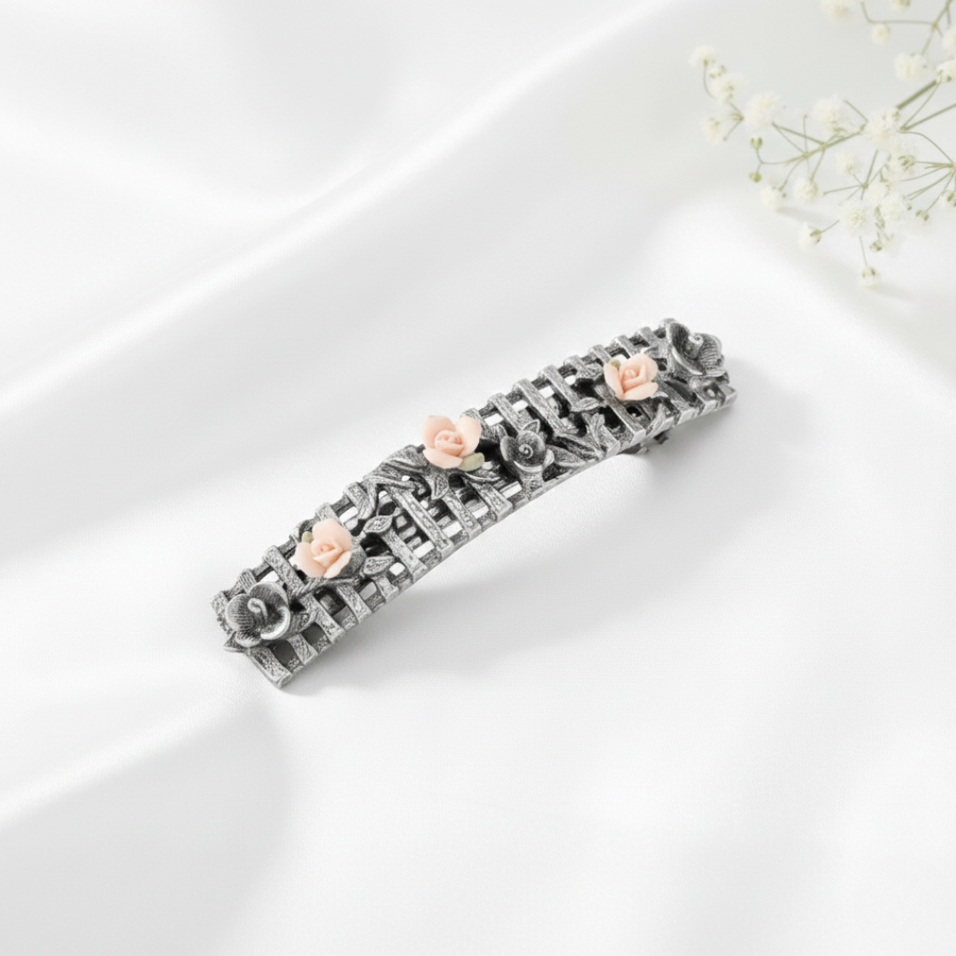 Decorative hair barrette with floral elements on a white surface.