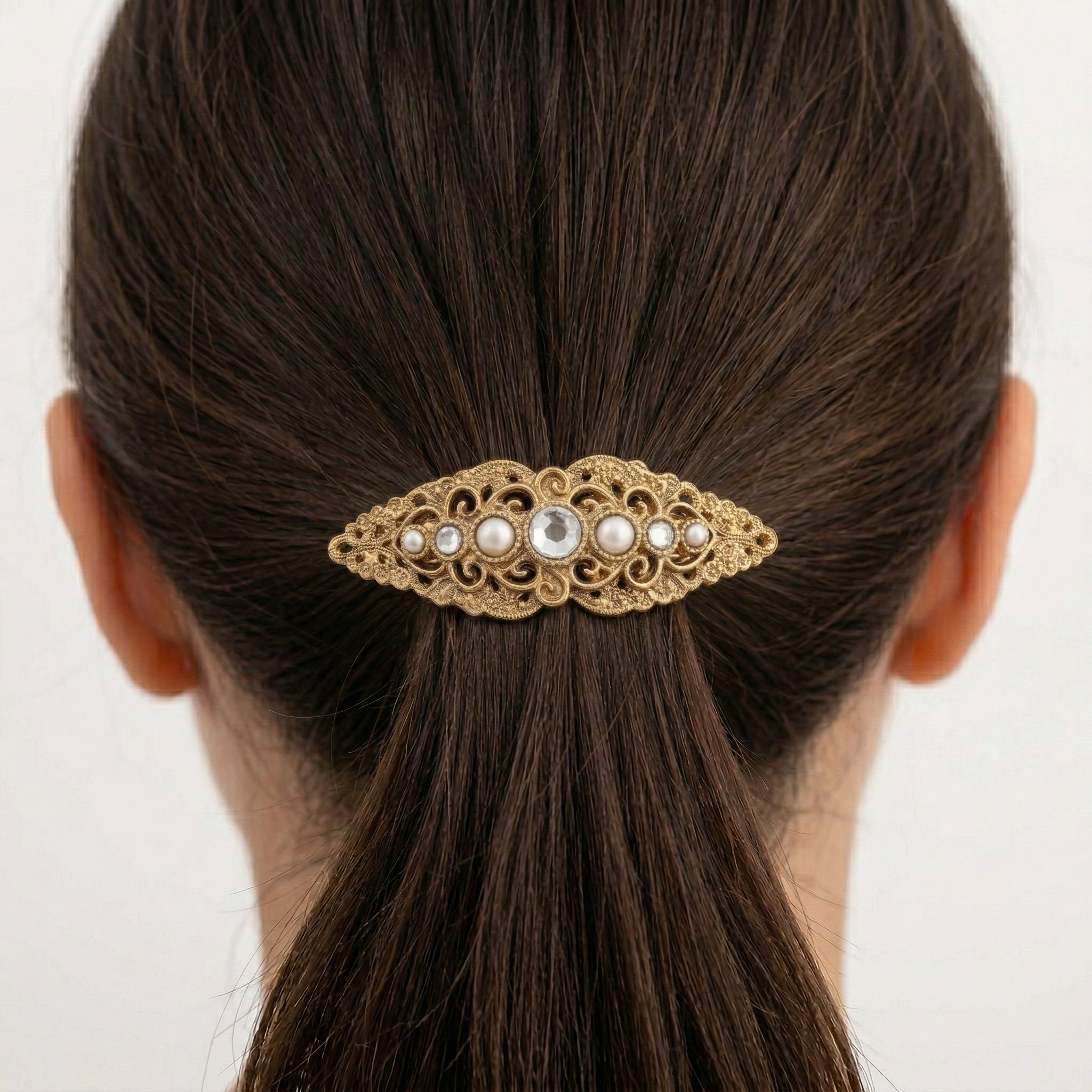 Gold tone Splendor Filigree & Stones Hair Barrette in a woman's bun with dark hair