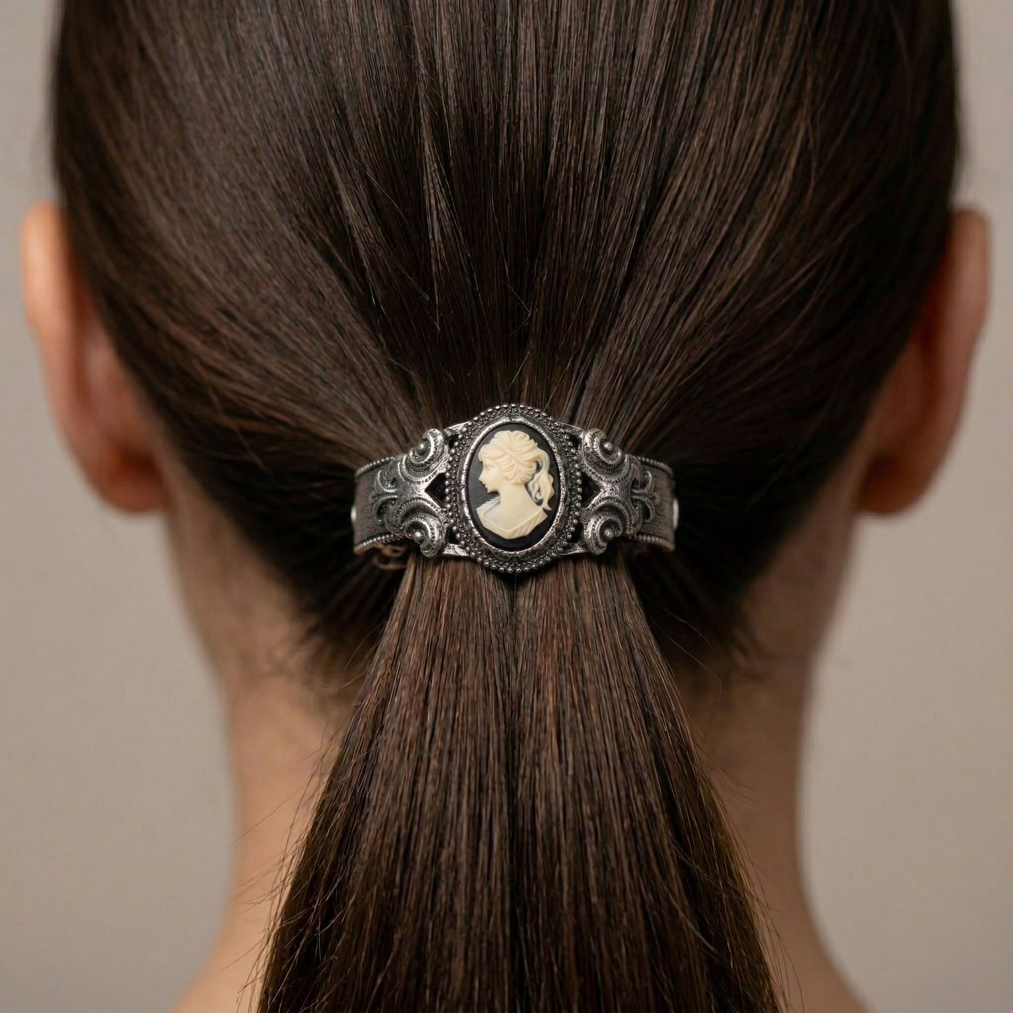 Vintage-style hair clip with a cameo design in a person's hair.