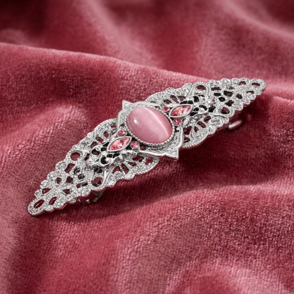 Decorative barrette with pink gemstone on a red fabric background