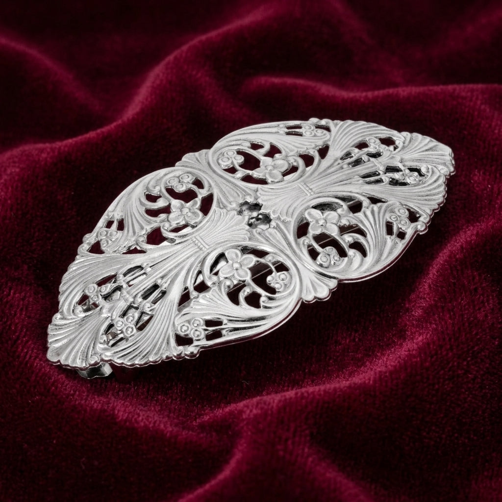 Silver floral barrette on burgundy-colored fabric
