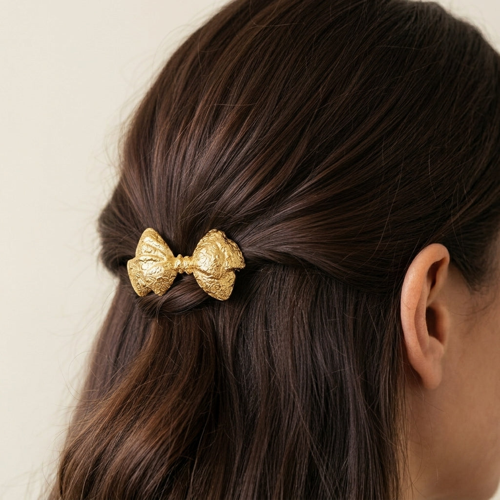 Woman with dark hair wearing a gold tone Floral Bow Silver Hair Barrette