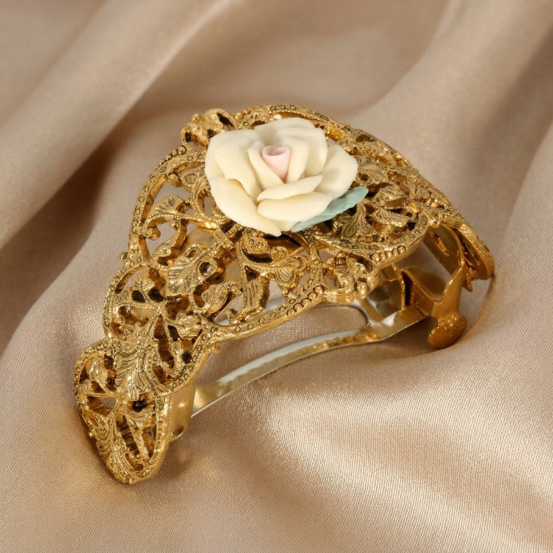 Gold barrette with floral porcelain rose design on a beige fabric background