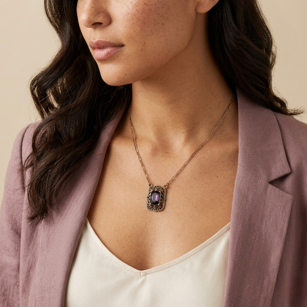 Woman wearing a necklace with a purple pendant against a beige background
