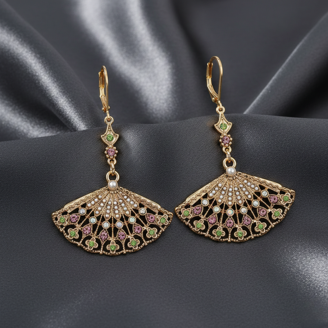 Ornate gold earrings with crystals on a dark fabric background