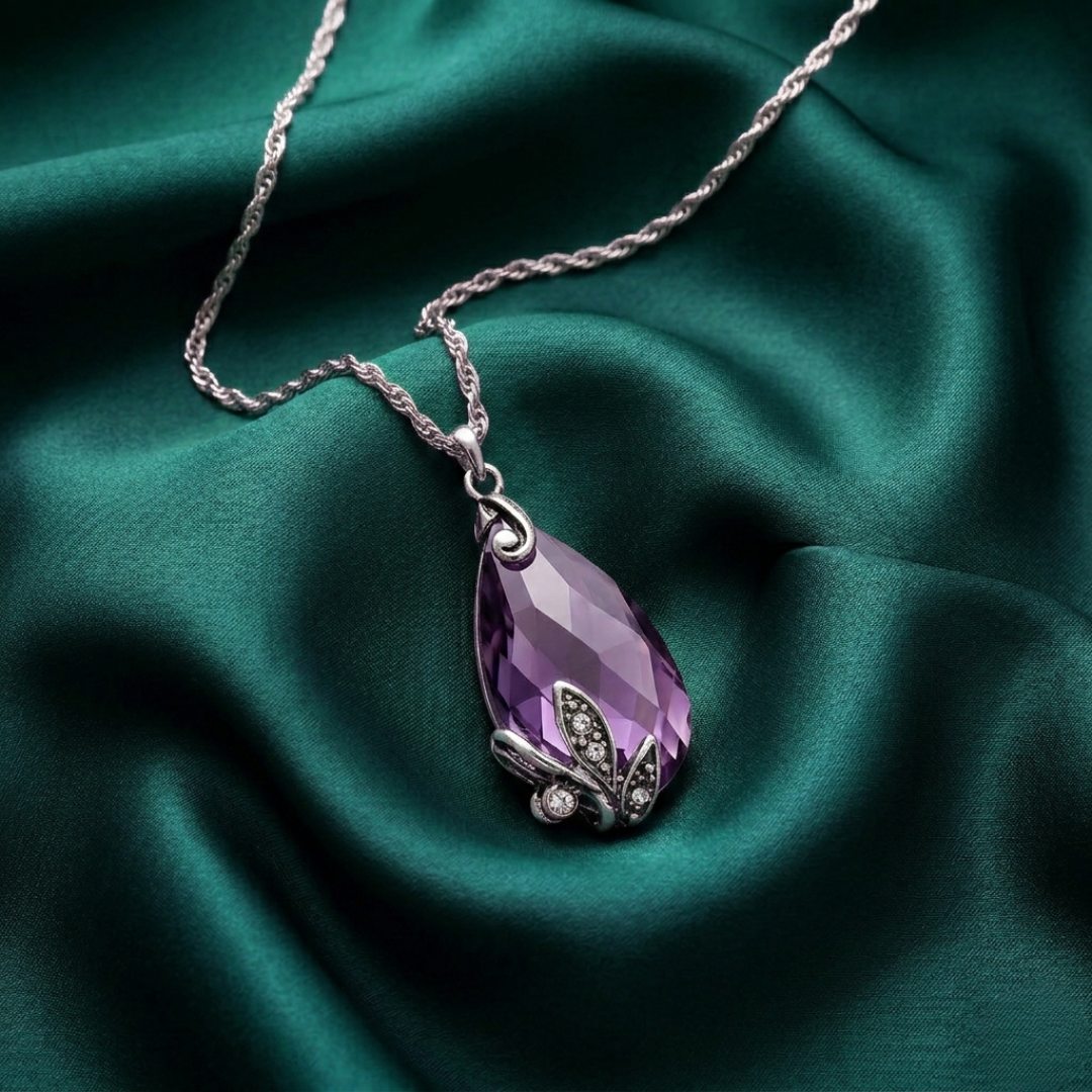 Purple teardrop pendant necklace on a green satin background