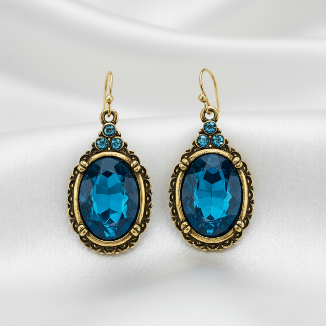Pair of gold-framed blue gemstone earrings on a white background