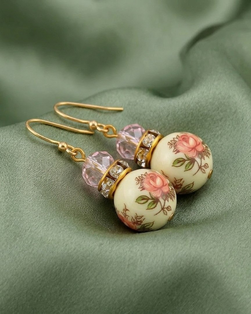 Pink Desert Rose Floral Decal Beaded Drop Earrings on light green fabric