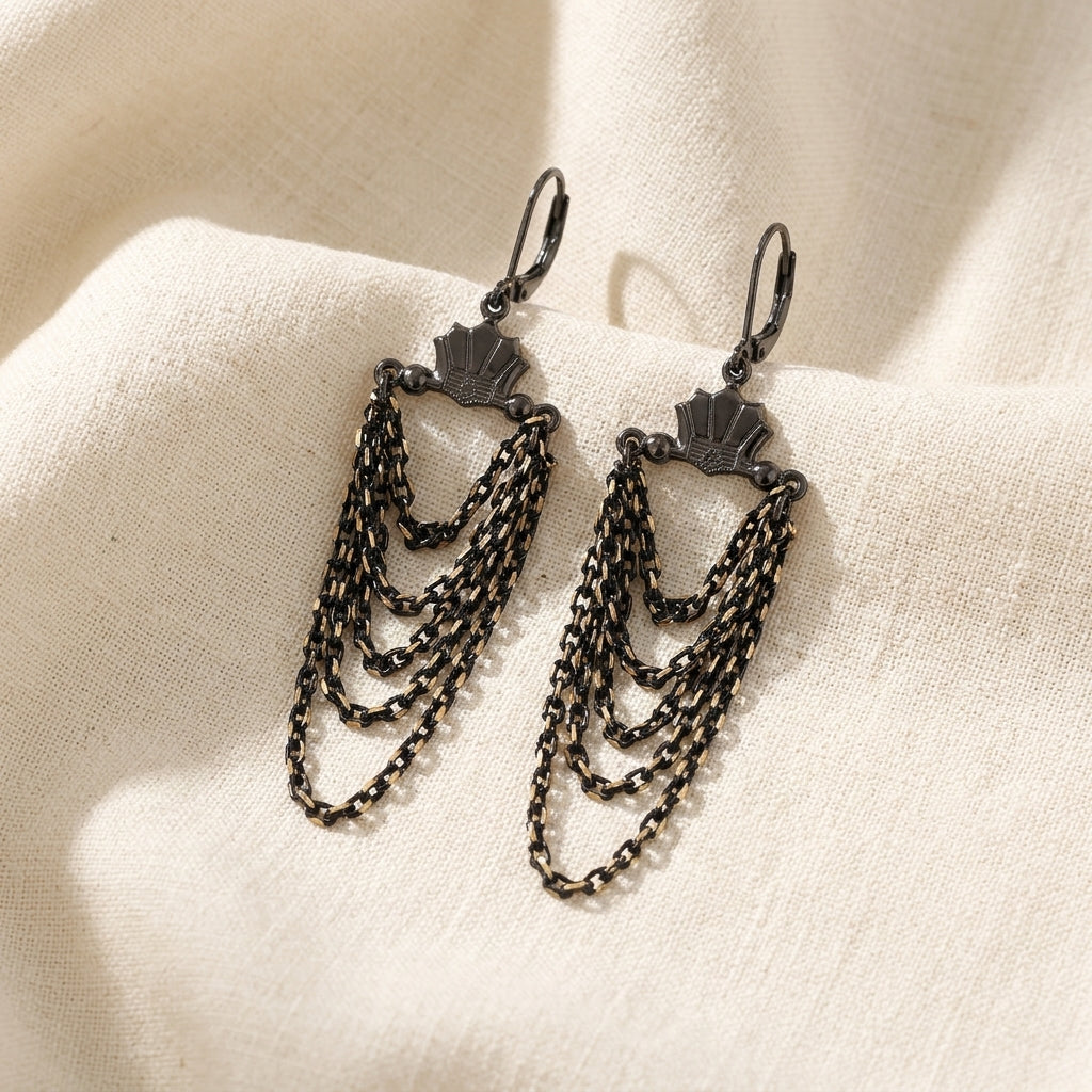 Eclipse Black And Gold Chain Layered Dangle Earrings resting on cream colored linen