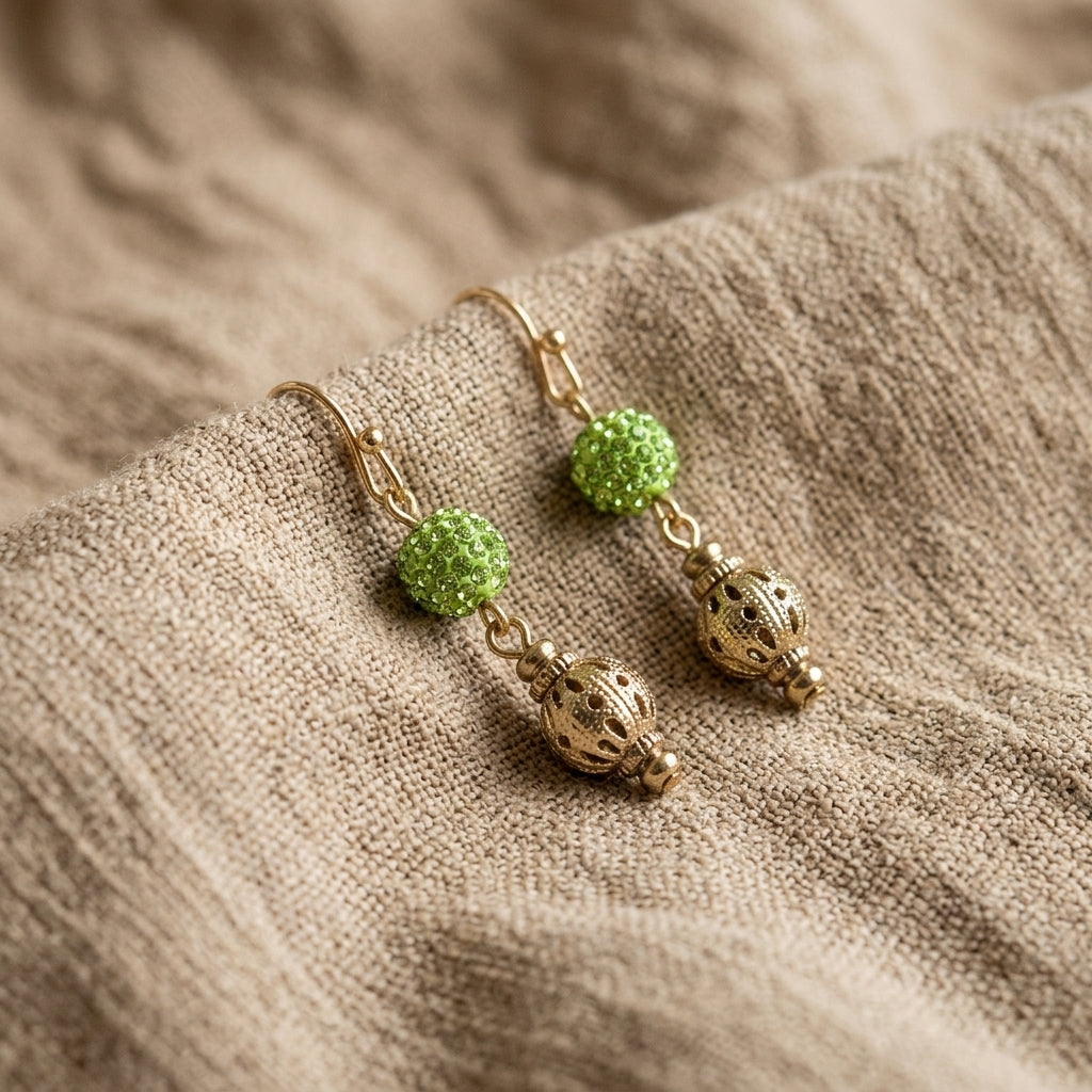 Fireball Pave Crystal & Filigree Dangle Earrings resting on tan linen