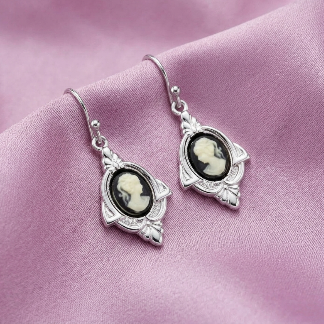 Black Cameo Drop Earrings on pink fabric background
