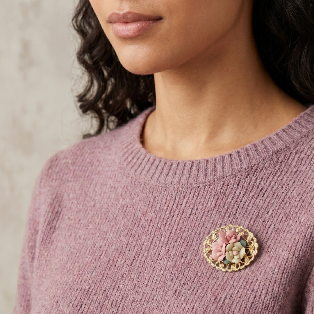 Close-up of a person wearing a pink sweater with a floral brooch.