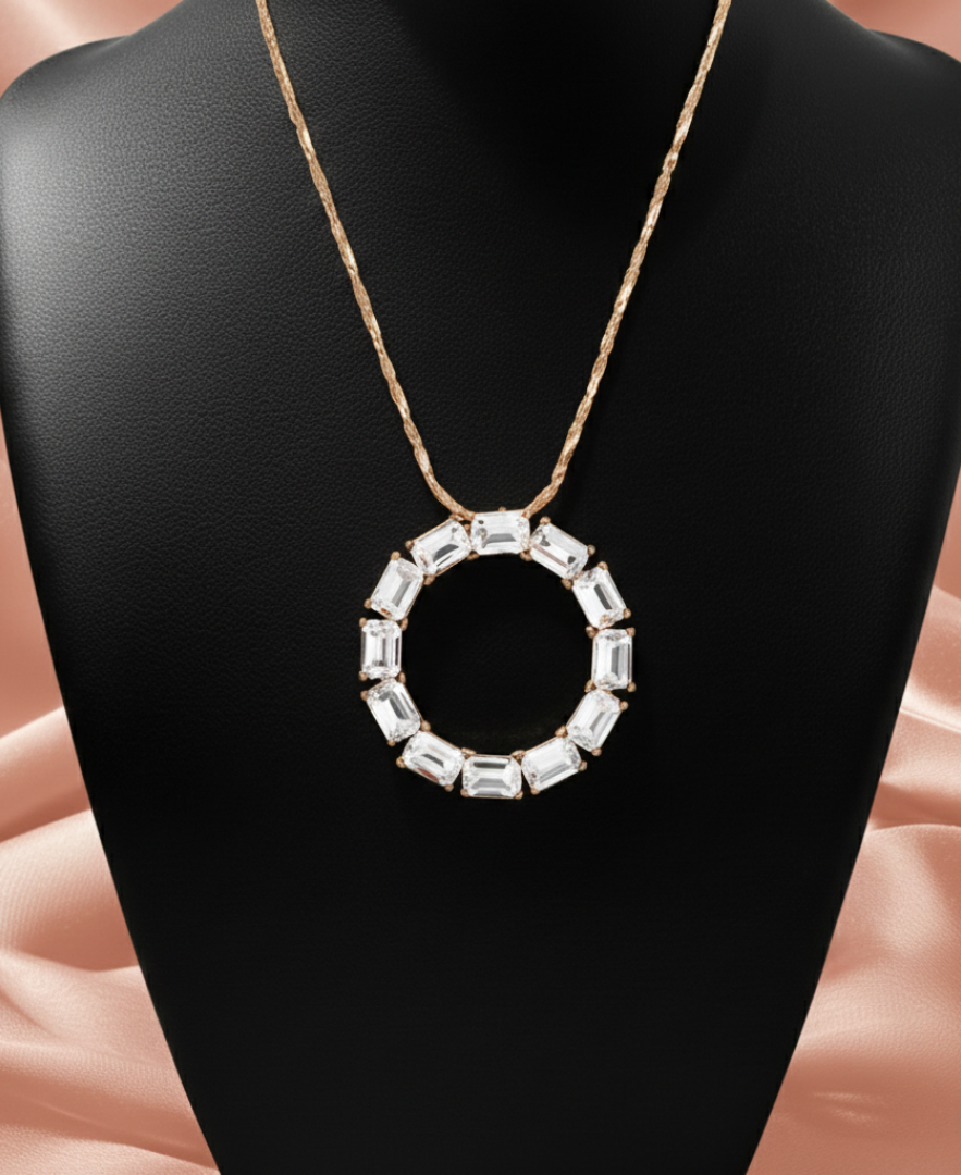 Crystal necklace with a gold tone chain on a black necklace display.