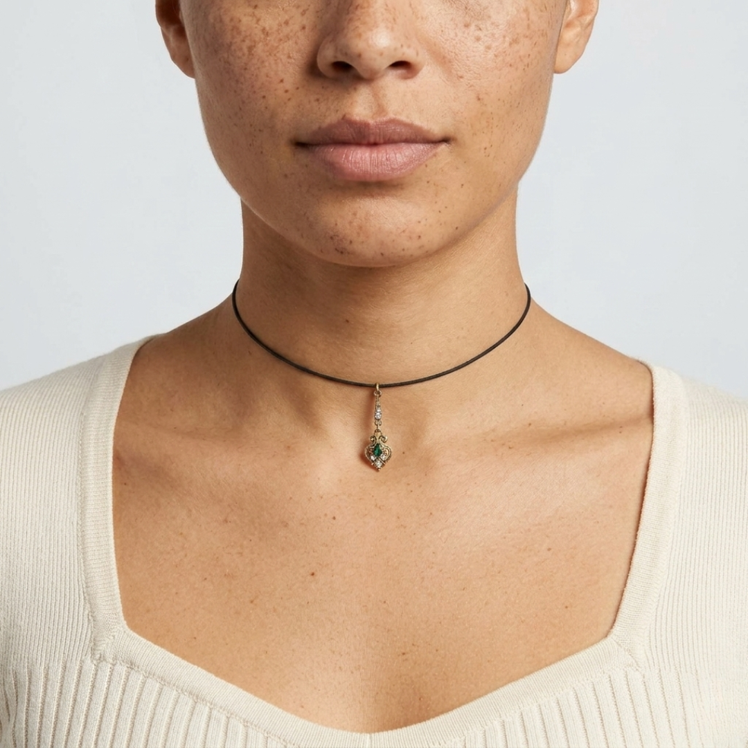 Person wearing a choker necklace with a pendant on a plain background