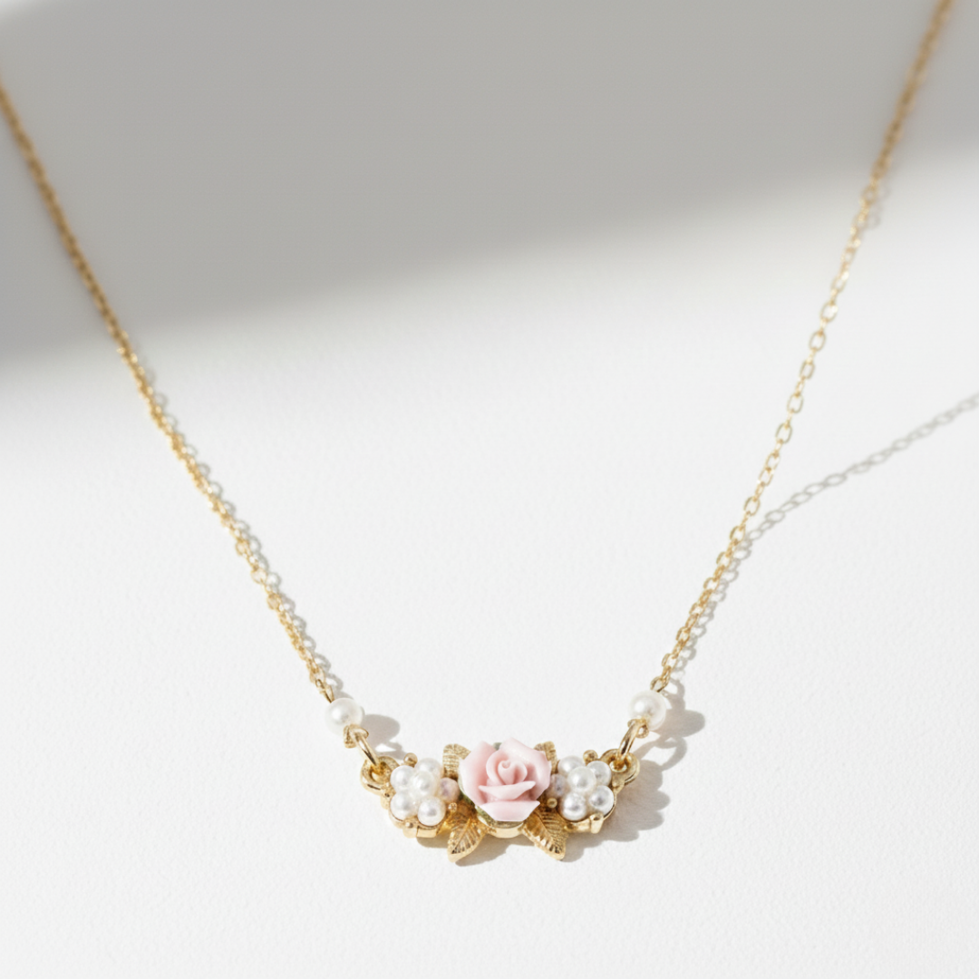 Delicate necklace with porcelain rose and faux pearl details on a light background.