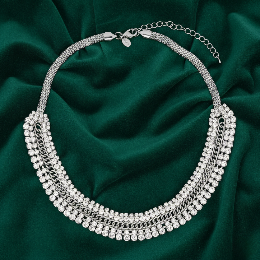 Silver necklace with multiple chains on a green fabric background