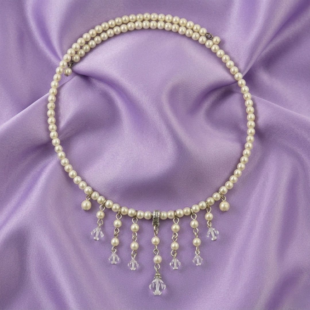 Faux pearl and clear crystal choker necklace on a purple satin background
