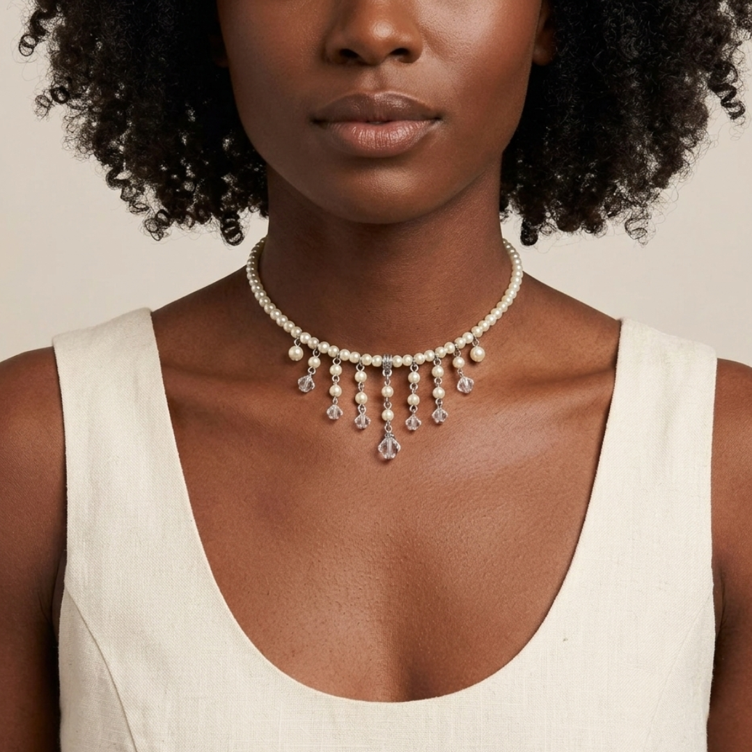Woman wearing a faux pearl and clear crystal choker necklace against a neutral background