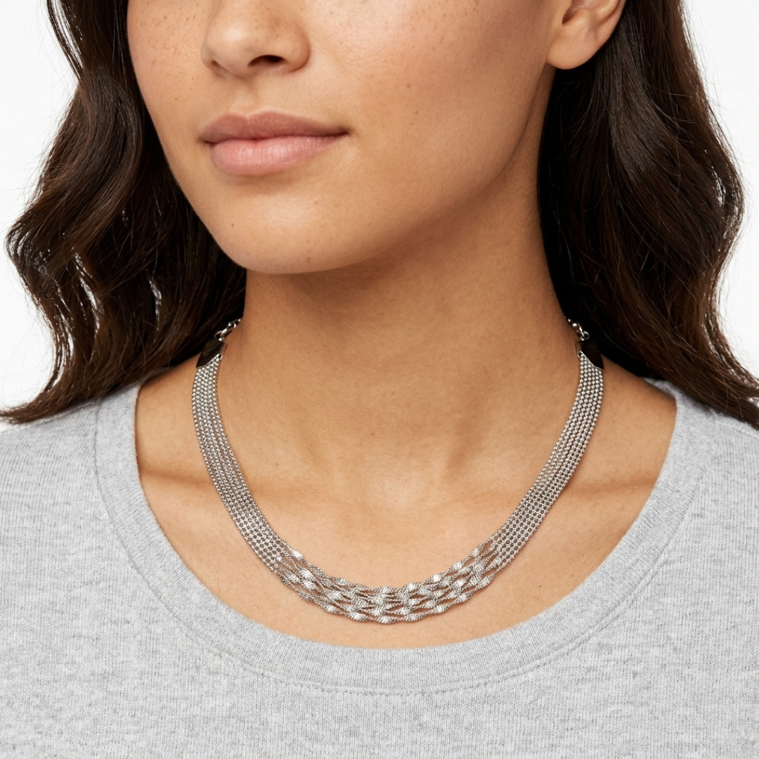 Silver necklace worn by a model on a white background