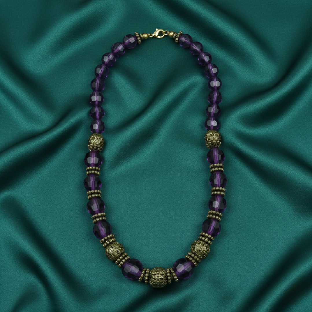 Purple beaded necklace with gold accents on a teal satin background