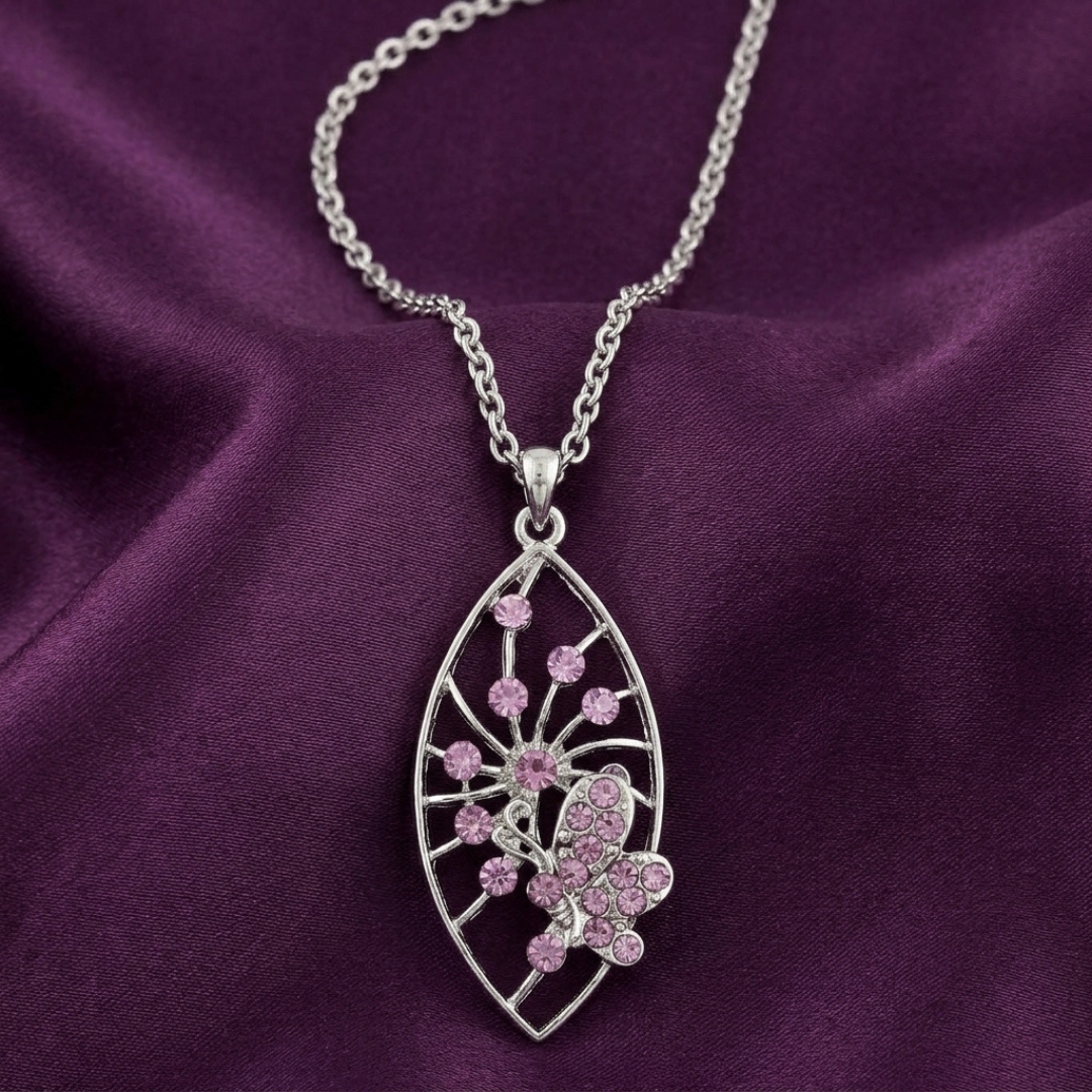 Silver necklace with a pink butterfly crystal pendant on a purple fabric background