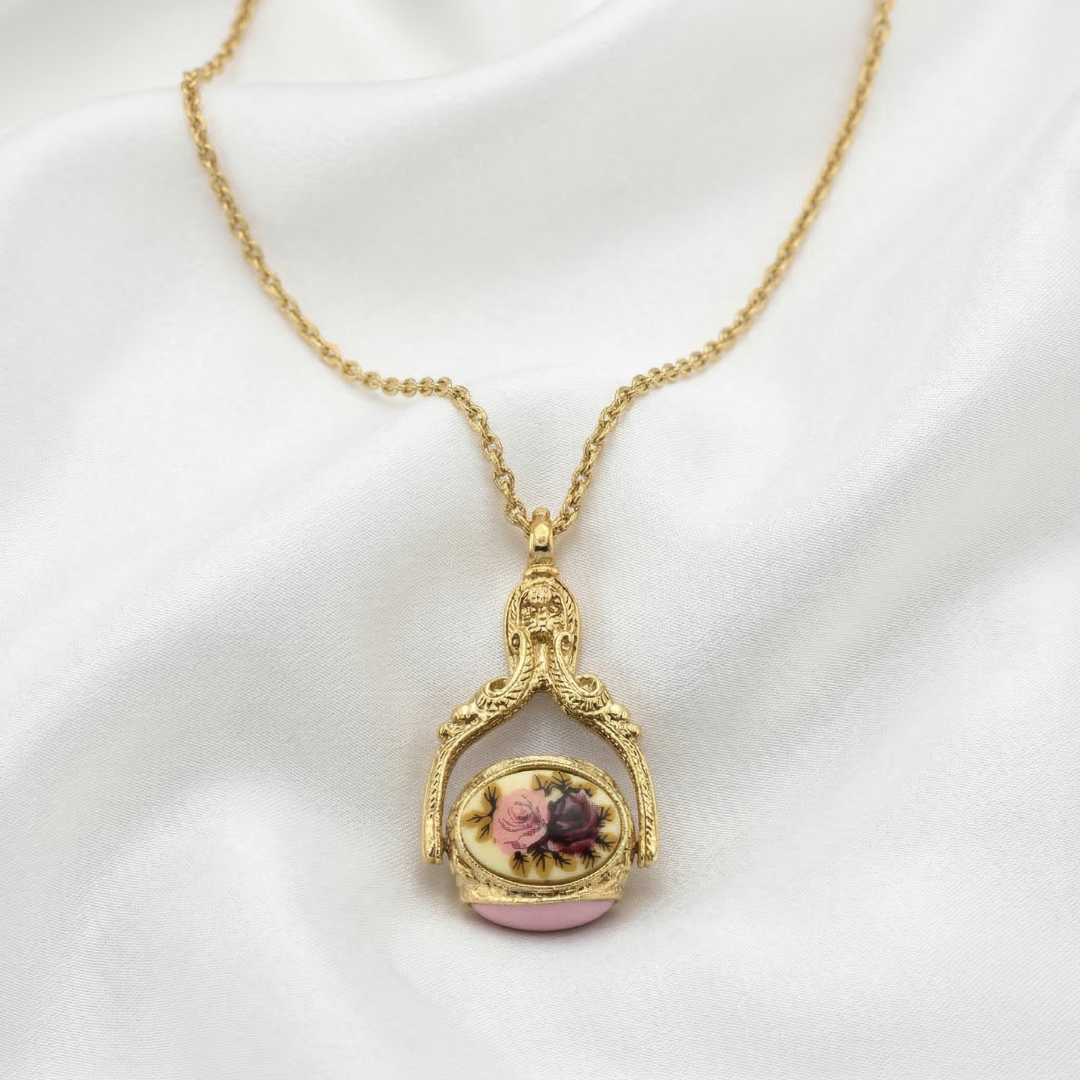 Decorative three-sided spinner pendant necklace with floral design on a white background