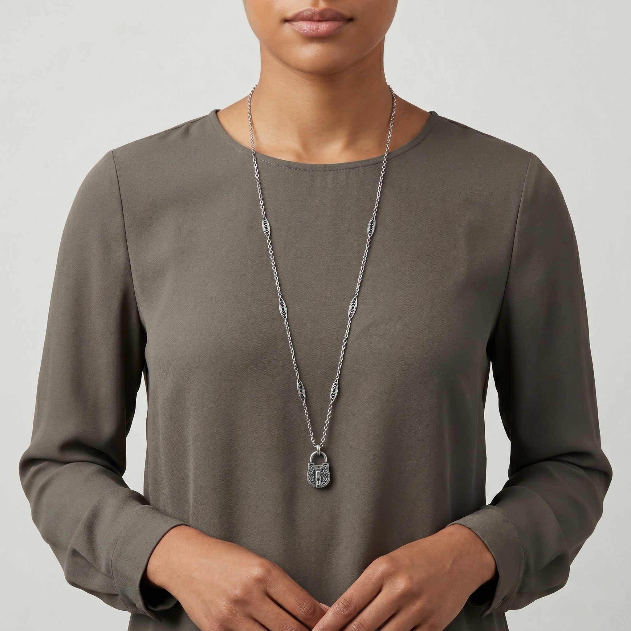 Person wearing a long-sleeve brown top with a Antiqued Pewter Lock Pendant Necklace