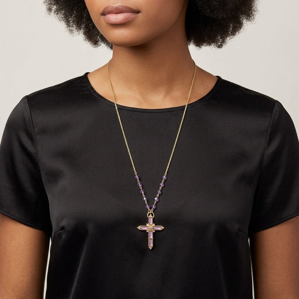 Woman wearing a black top with a gold and purple beaded necklace featuring a cross pendant.