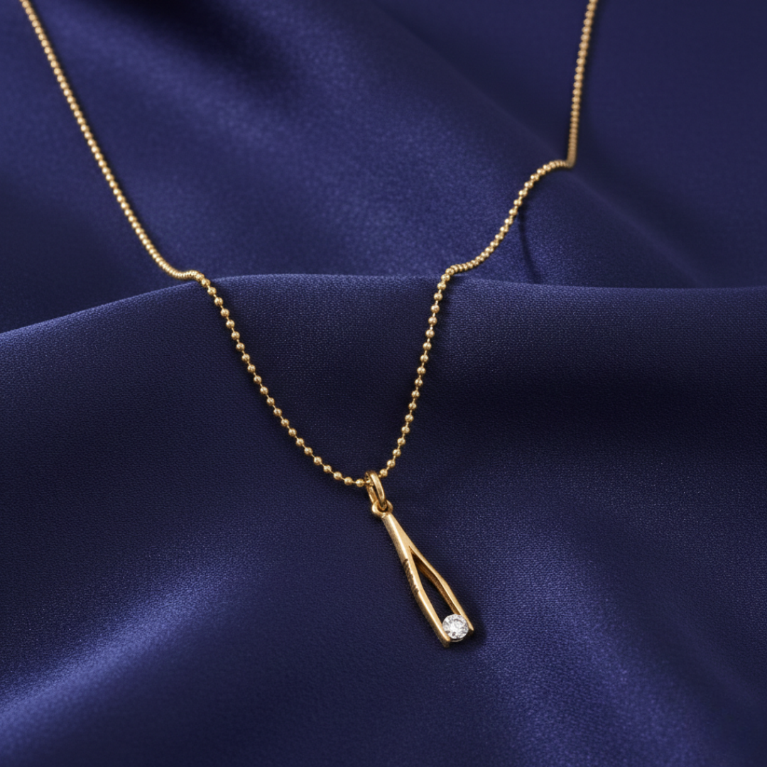 Gold necklace with a pendant on a blue fabric background