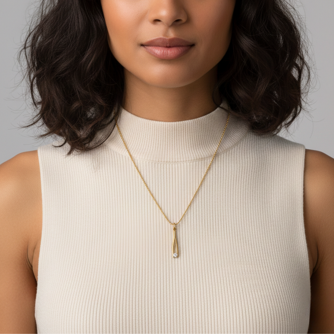 Woman wearing a gold necklace with a pendant against a neutral background