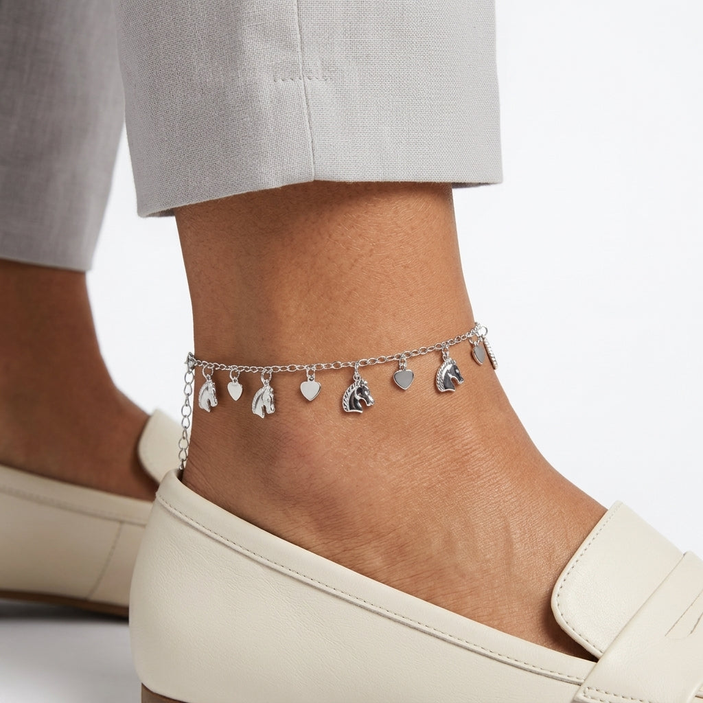 Anchored anklet with heart and horse-shaped charms on a person's ankle against a neutral background