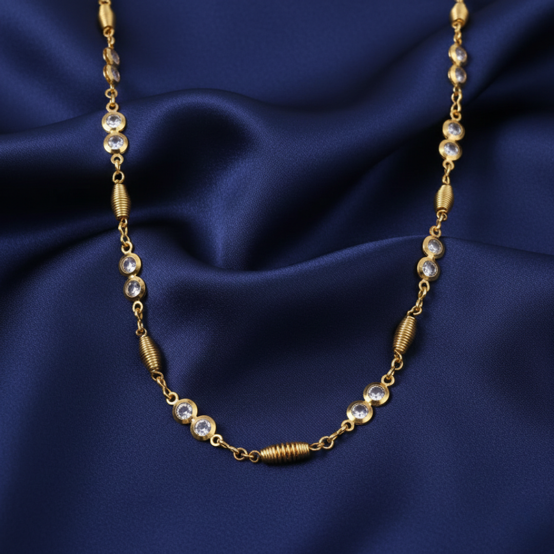 Gold necklace with clear crystals on a blue satin background
