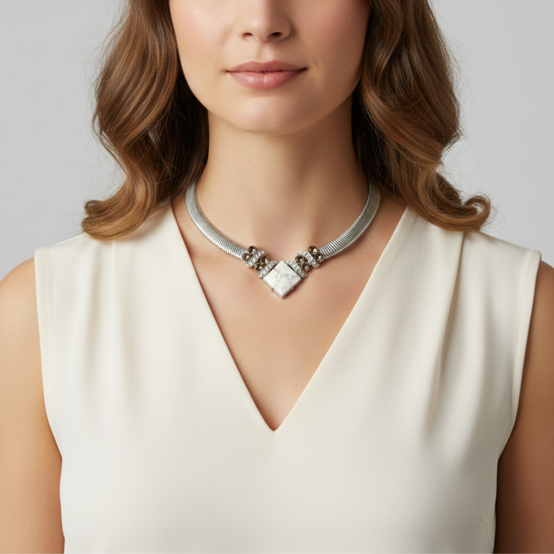 Woman wearing a silver necklace with a neutral background