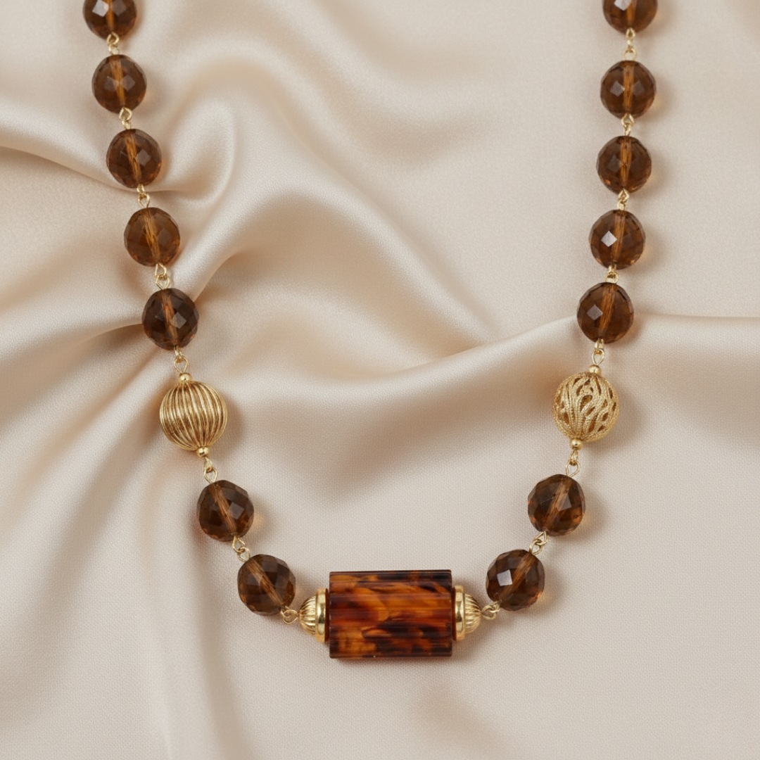 Necklace with topaz beads and gold accents on a beige fabric background