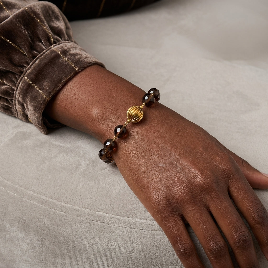 Hand wearing a bracelet with brown beads on a neutral background