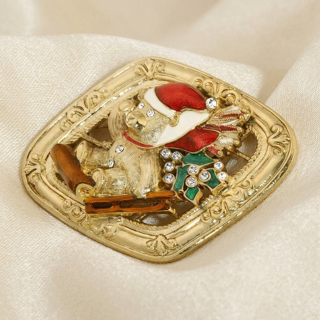 Gold brooch with a festive design of a teddy bear on a sled in a Santa hat on a beige fabric background