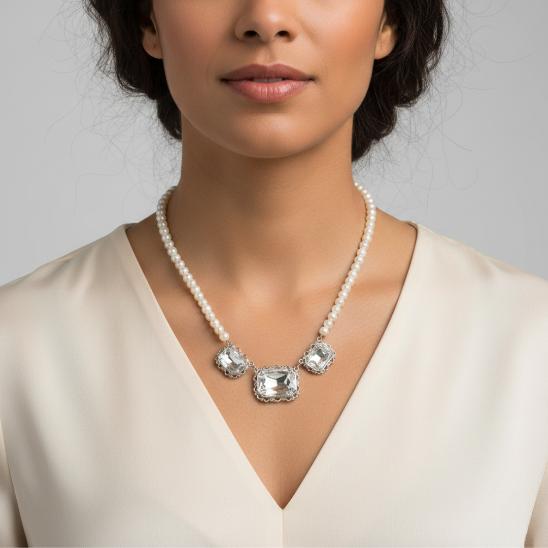 Woman wearing a faux pearl necklace with three large crystal pendants against a neutral background