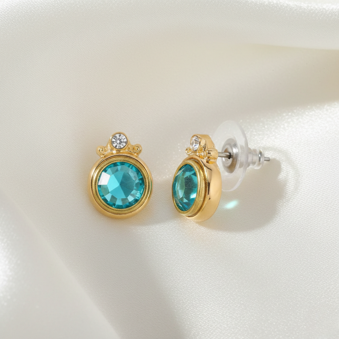 Gold earrings with turquoise crystals on a white background