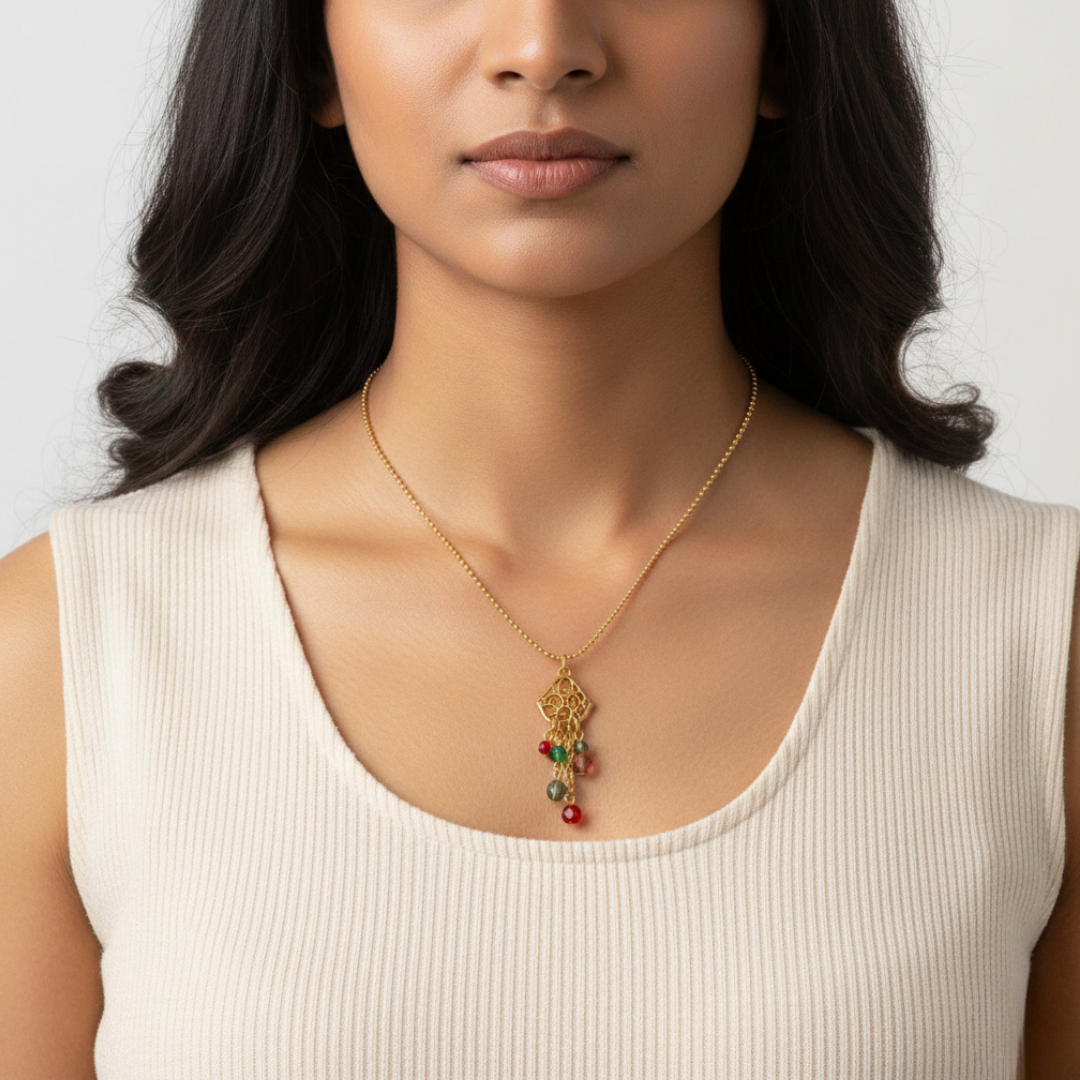 Woman wearing a gold necklace with colorful beads against a neutral background