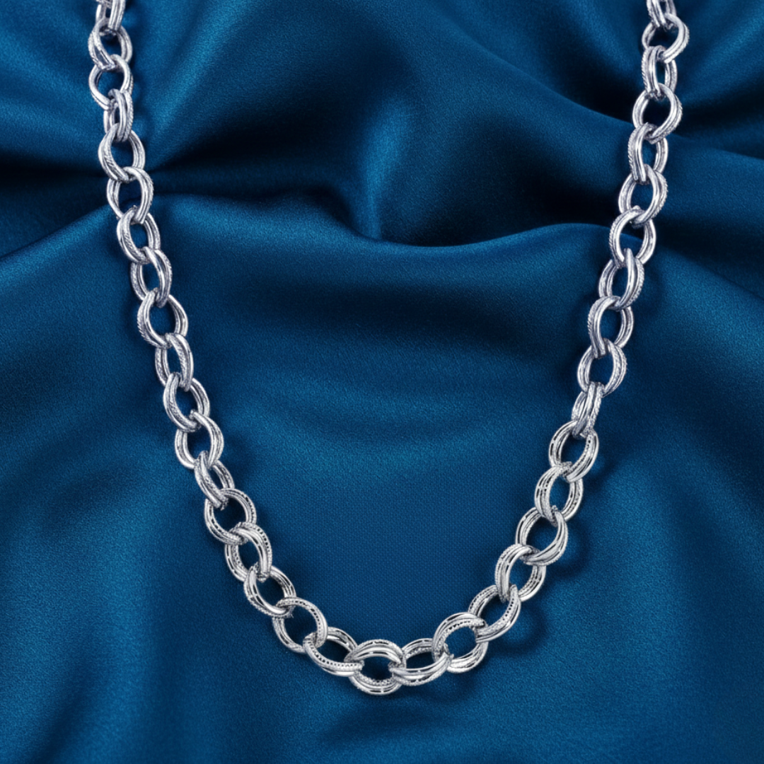 Silver chain necklace on a blue satin background