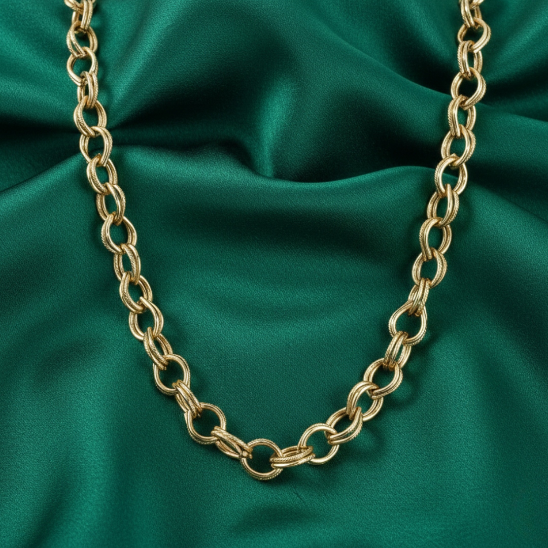 Gold chain necklace on a green satin background