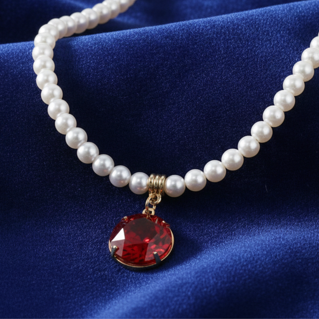Pearl necklace with a red gemstone pendant on a blue fabric background