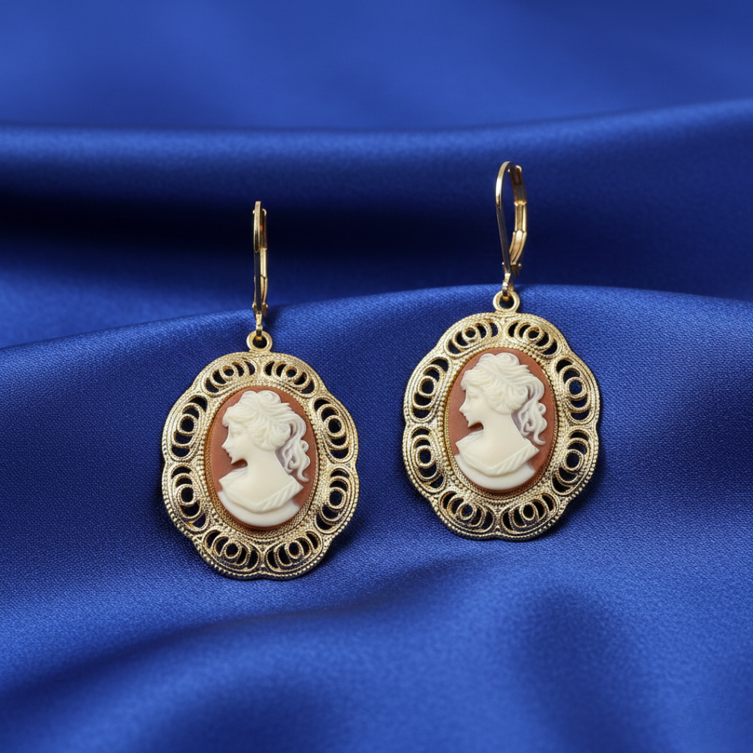 Gold-framed red cameo earrings on a blue satin background