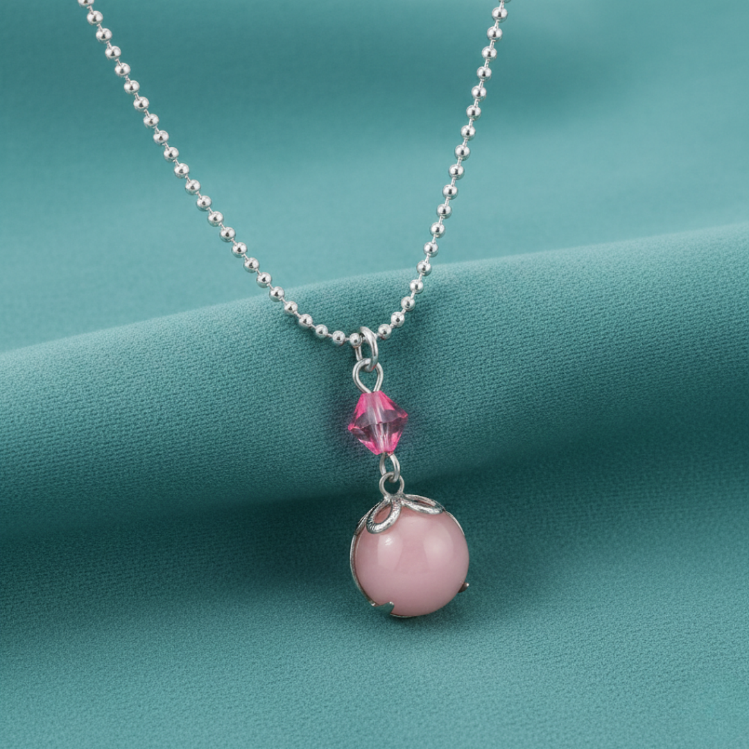 Necklace with pink bead and crystal on a teal background